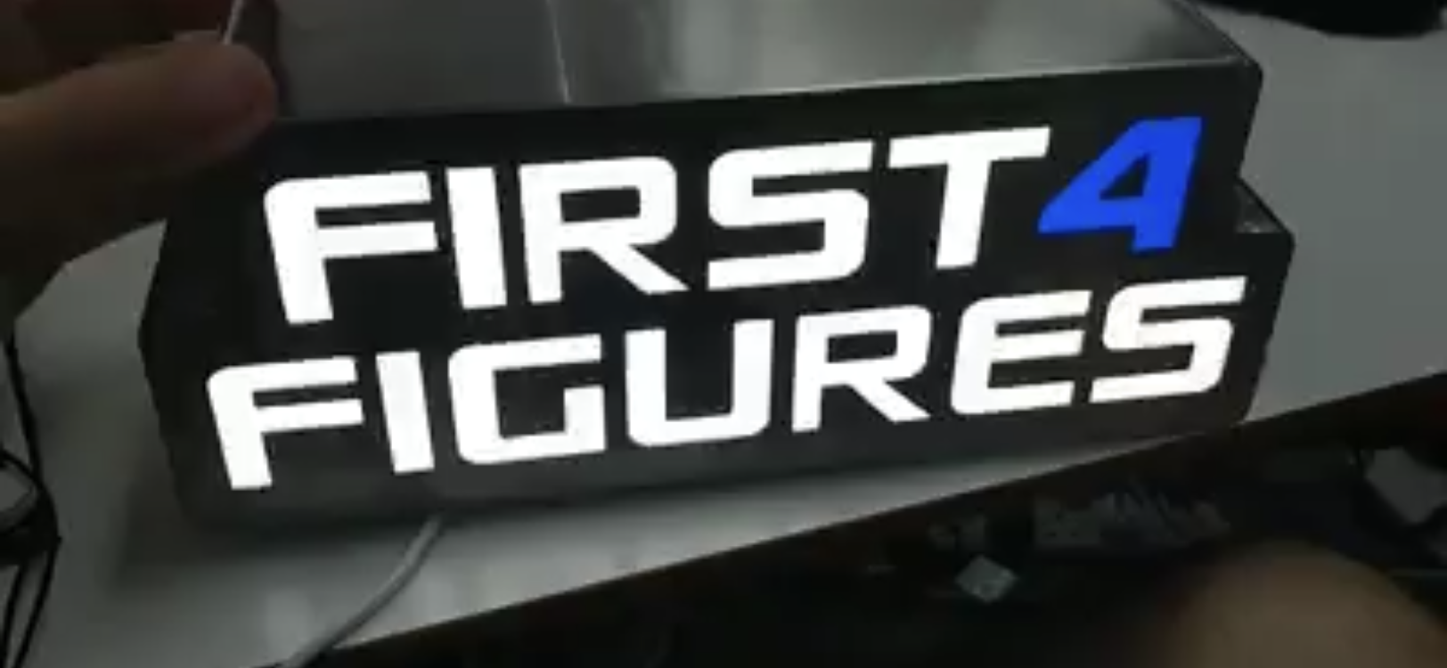 First 4 Figures Logo Sign for New Studio